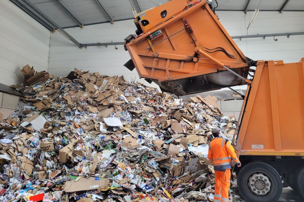 A man loads a large pile of garbage into a truck for bulk junk removal in Tampa, FL, showcasing efficient waste management.