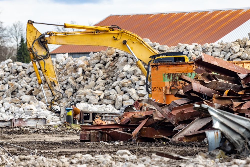 A bulldozer and a large pile of rubble are visible, representing a demolition service in Tampa, FL.